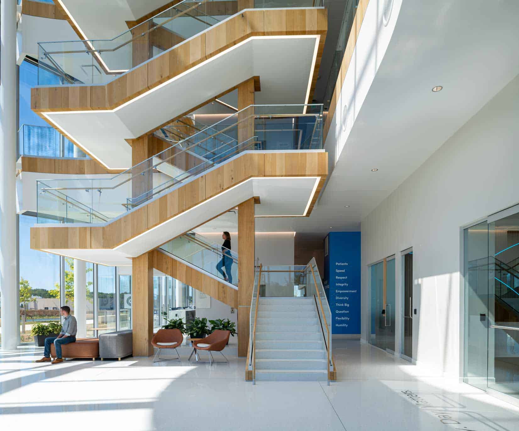 Live Sawn White Oak Wood Veneer Paneling installed on the staircase in a corporate office atrium