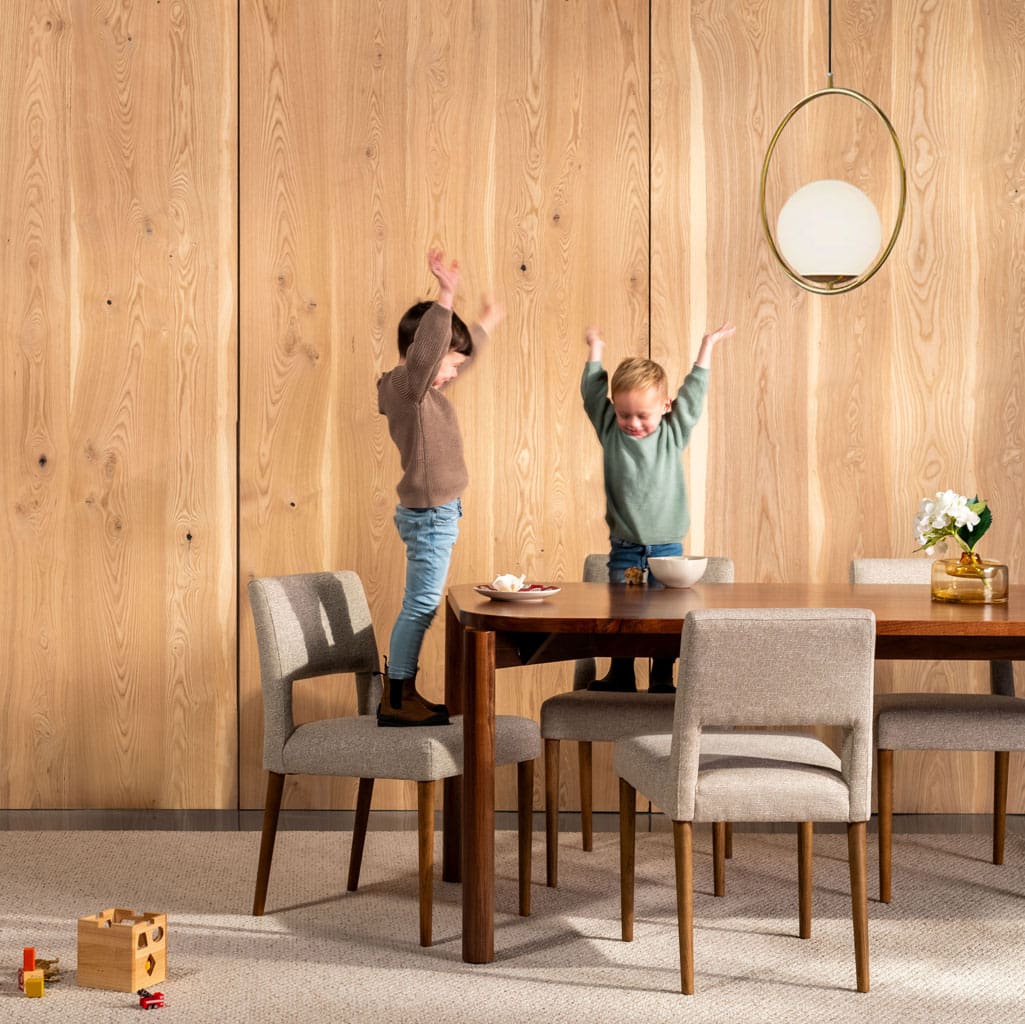 Two children at a dining room table in front of Select Heart Ash Veneer Wood Wall Paneling