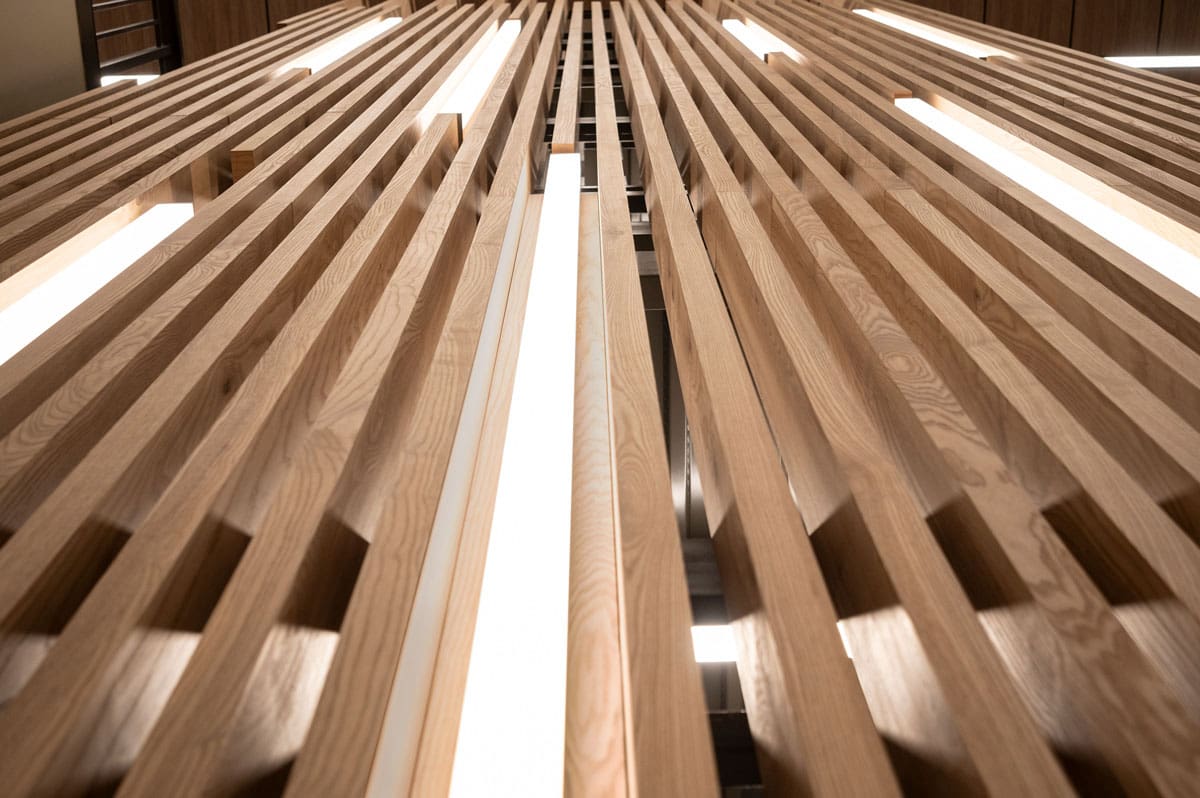 Urban Ash Wood Pass Through Slats with vertical lighting in a wood feature wall