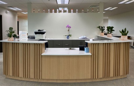 Reception Desk Featuring Custom Wood Wall Panels in Fin White Oak