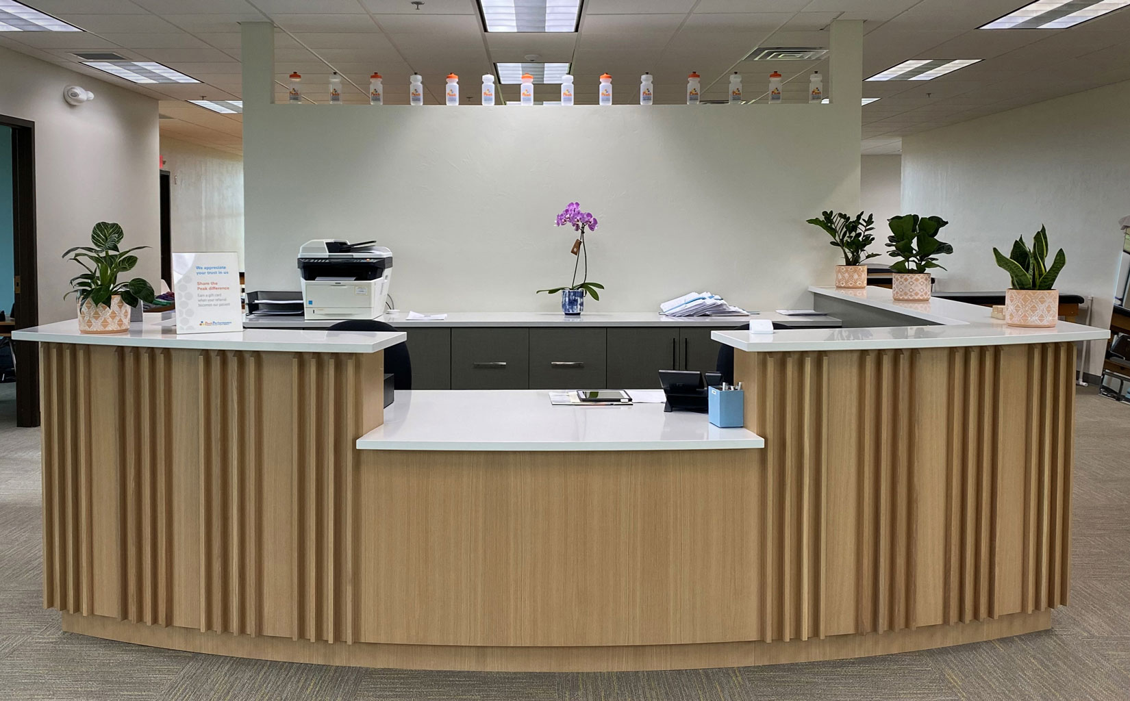 Reception Desk Featuring Custom Wood Wall Panels in Fin White Oak